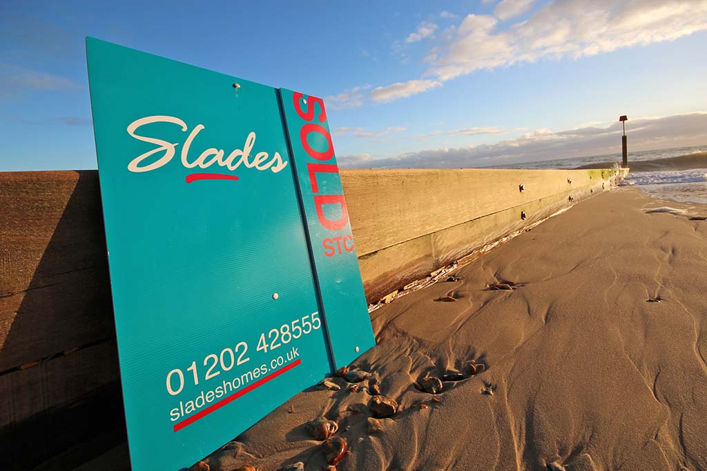 Slades Estate Agents - Sold board on the beach